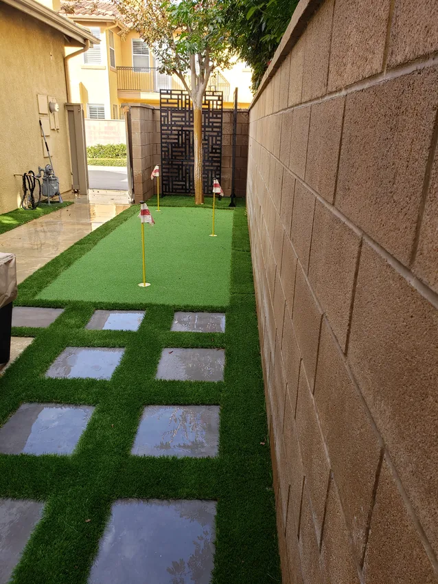 Narrow side-yard putting green with three flags and stepping stones between turf strips